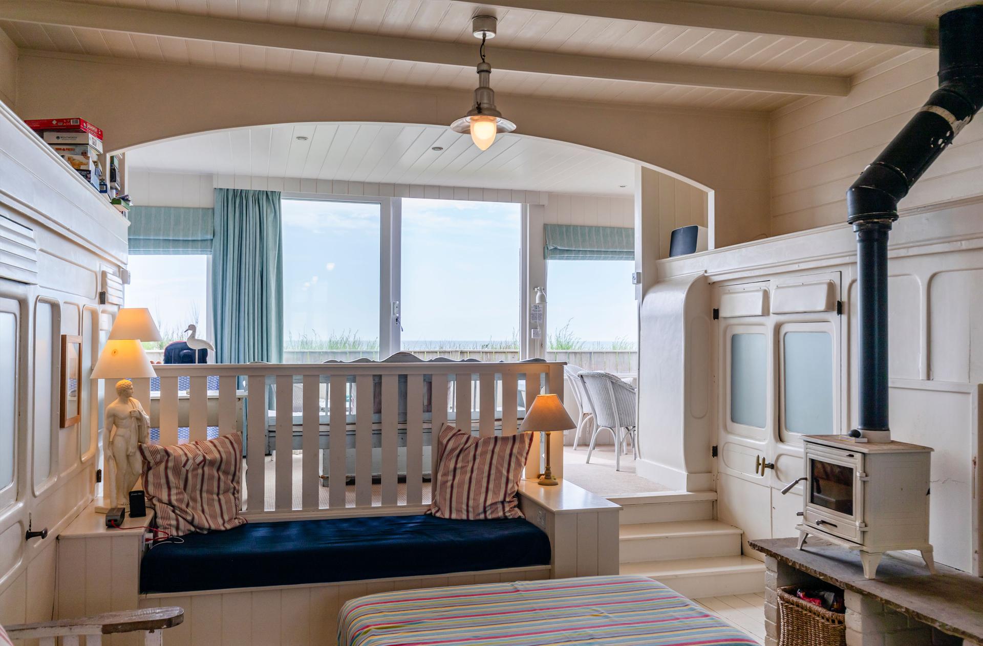 The Dodo Image A set of chairs in a spacious room next to an accessible terrace with a view of the sea.